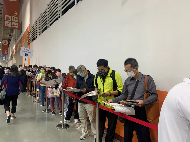 許多民眾低頭研究餐券優惠。胡順惠攝