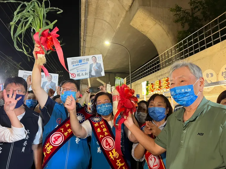 新竹縣長候選人楊文科12日晚間於竹東鎮沿河街夜市掃街，攤商熱情送上好彩頭。楊文科競辦提供