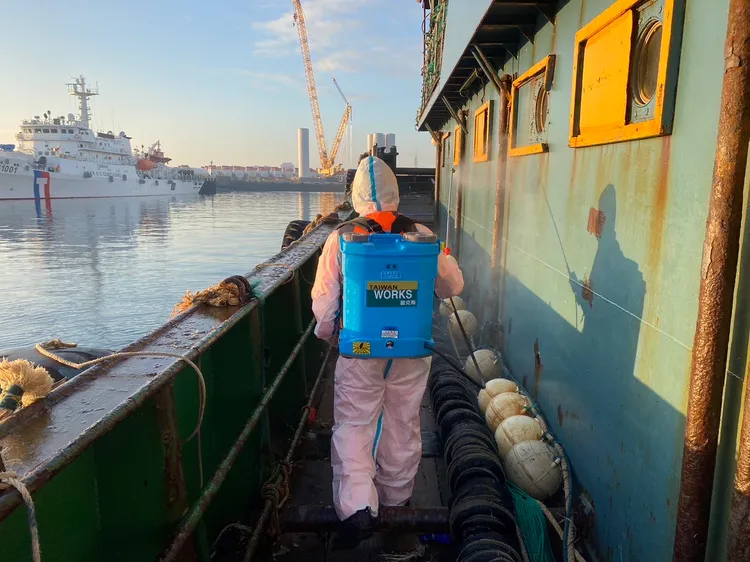 防疫人員進入查扣中國籍漁船進行清消作業。台中海巡隊提供