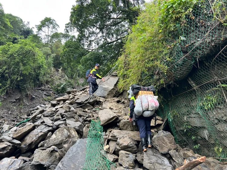 邊坡因大雨坍塌，大量土石崩落，搜救五虎將冒險高繞挺進。警方提供
