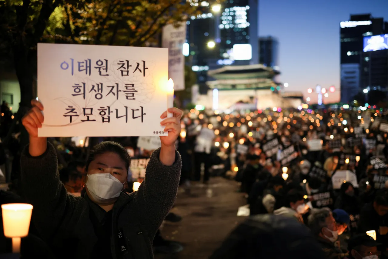燭光晚會人士高舉寫有「紀念梨泰院踩踏死者」的海報。路透社
