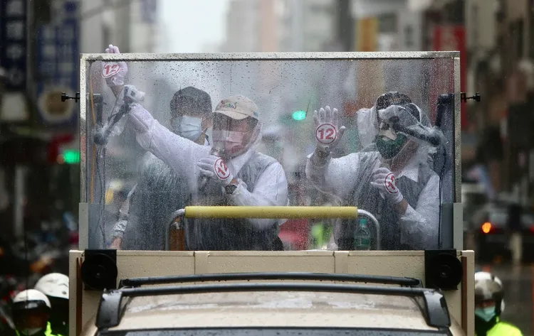 陳時中與陳建仁在雨中車掃。林林攝