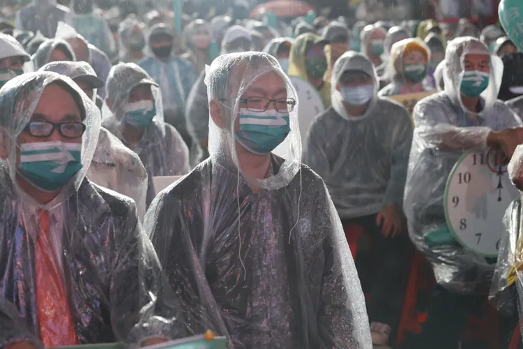 薛瑞元今晚穿雨衣力挺陳時中。鄭孟晃攝