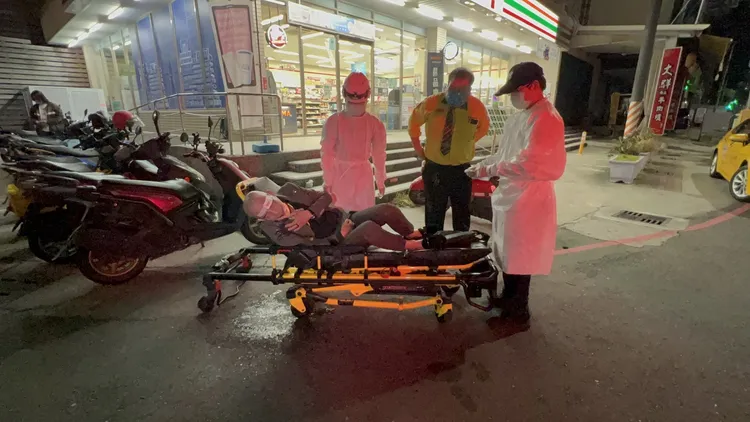 醉男坐上擔架後開始狂吐。侯昌騰攝