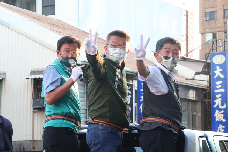 陳時中跟蔡其昌登戰車跟中西東南舊城區民眾拜票，轉身比出2號蔡其昌的號次拜託民眾支持。張喆喜攝