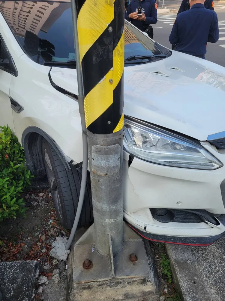 盧男被逮捕後，汽車繼續往前滑行，撞上路燈桿，幸無人受傷。讀者提供