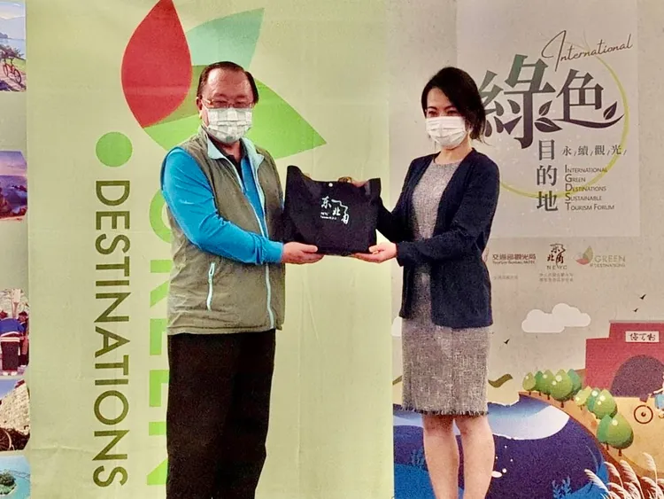 東北角暨宜蘭海岸國家風景區管理處處長馬惠達（左）與日本二世谷町役場商工觀光課代表鈴木惠里互致贈禮物。新北市政府提供