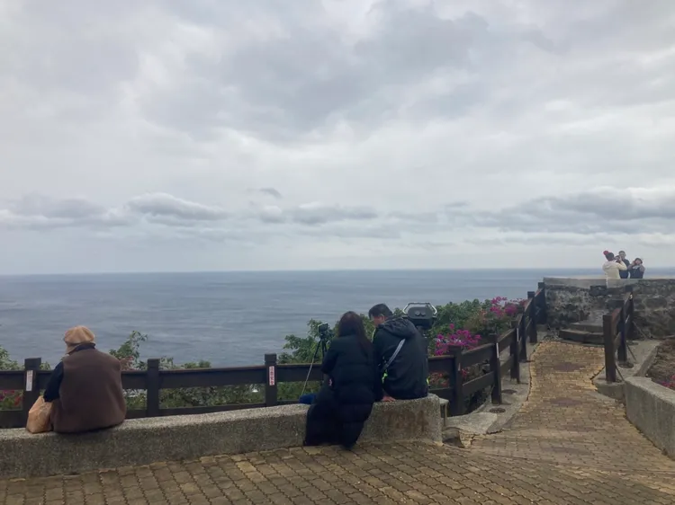 原本還有遊客靜坐平台待落日，下雨後遊客紛離去。陳宏銘攝