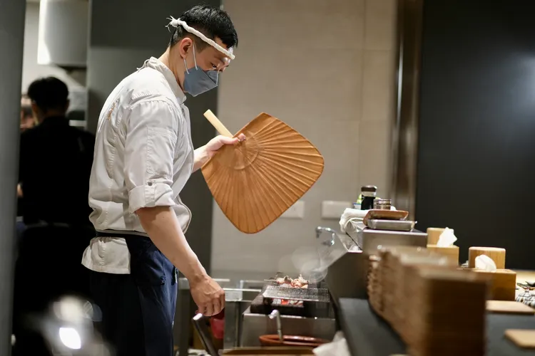 台北鳥喜店長蔡宗倫Allen示範以高溫備長炭烤炙，並加上蒲扇增加火勢的烤法。陳志淵攝