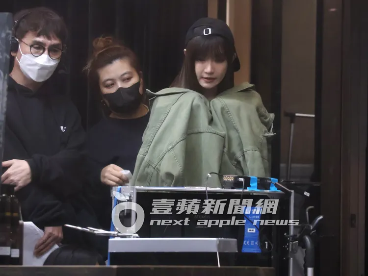 女神謝金燕（右）披著外套保暖，邊看回放螢幕，助理一邊幫她整理造型。特勤中心攝