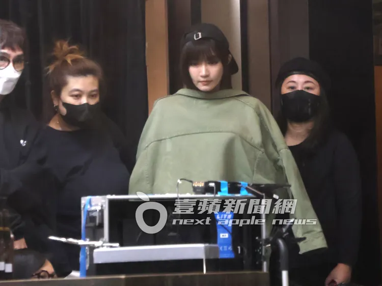 女神謝金燕（中）披上夾克外套保暖，一邊看著錄影回放螢幕。特勤中心攝