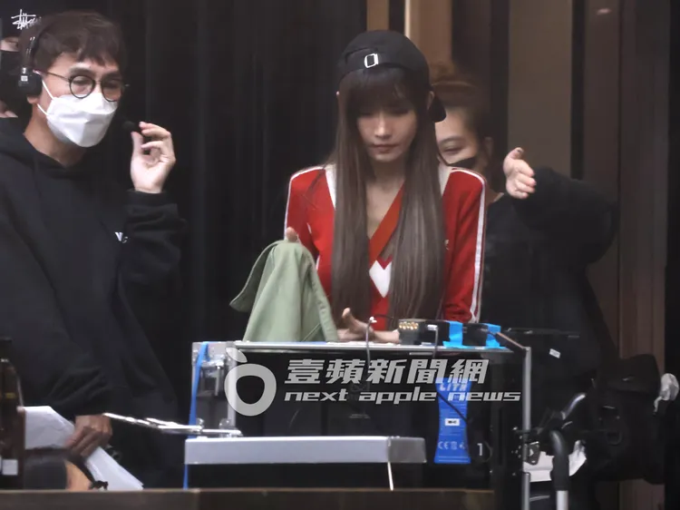 女神謝金燕（中）邊看著拍攝影片，邊脫下夾克外套，準備繼續上工。特勤中心攝