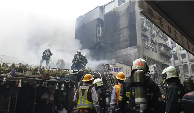 消防人員爬上鐵皮屋灌救火勢。翻攝畫面