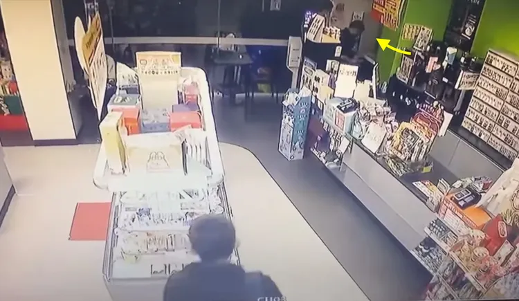 其中一名竊賊把店員支開協助影印工作（箭頭處），好讓另一人偷走商品。民眾提供