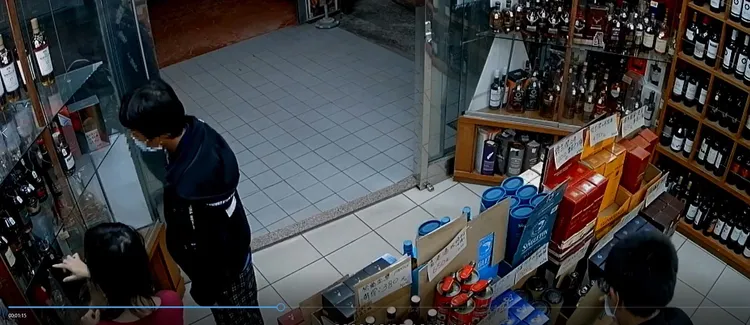 2名嫌犯分工，一人藉機吸引店家目光，另一人乘機偷洋酒。民眾提供