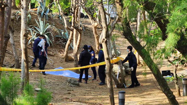 林男在樹叢內輕生，警方蒐證後覆蓋白布等候相驗。許逸民攝