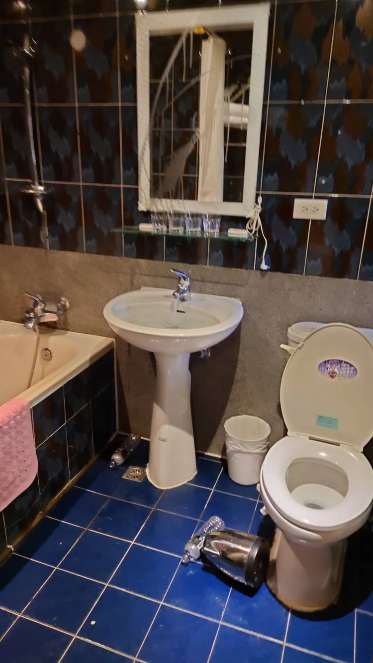 被害旅店的浴室被羅男弄得一片凌亂，洗手台的水也沒關。讀者提供