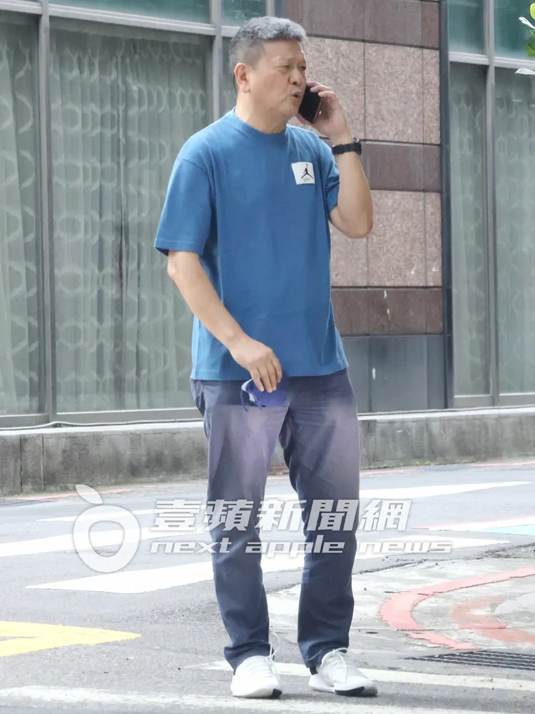 閻家驊教練站在林森北路上，脫下口罩，口沫橫飛講手機，表情看來不悅。特勤中心攝