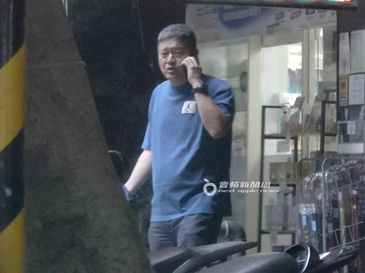 閻家驊教練邊激動講電話，邊過馬路走到騎樓內繼續喬事情。特勤中心攝