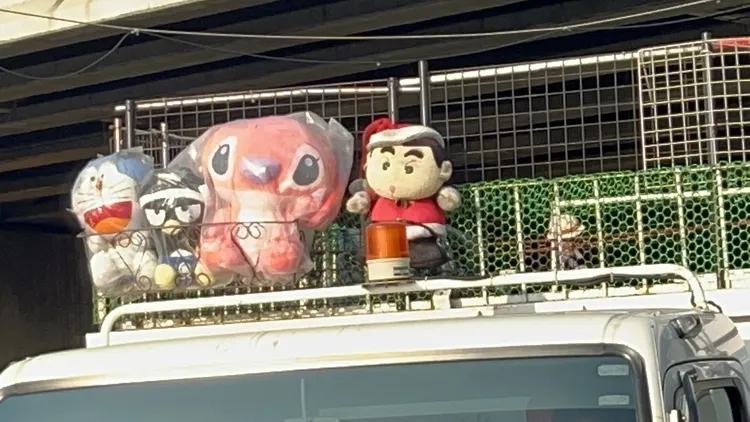 這輛白色資源回收車貨斗不僅用鐵網加高作為柵欄，還綁上蠟筆小新、多啦A夢布偶。侯昌騰攝