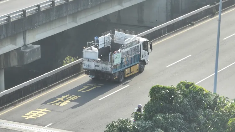 一輛白色資源回收車後方的貨斗用保麗龍板、鐵網充當柵欄，增加貨斗的高度。侯昌騰攝