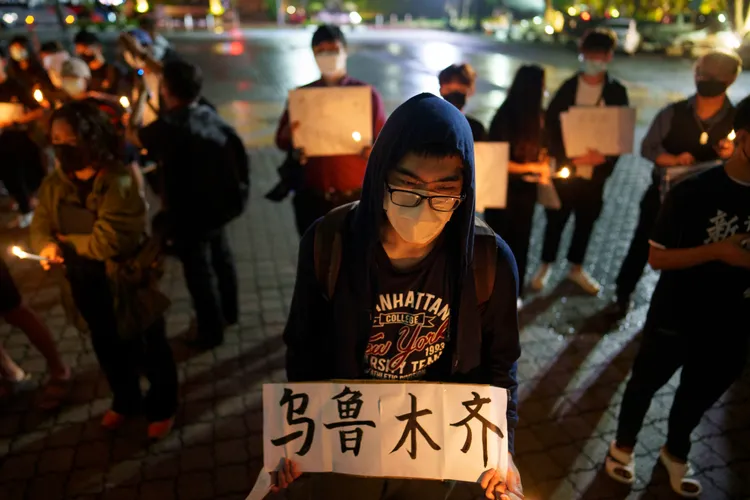 11月29日在馬來西亞吉隆坡街頭要求解封的民眾，手持寫著「烏魯木齊」的白紙為11月下旬新疆烏魯木齊封控民眾死於大火一事哀悼。美聯社