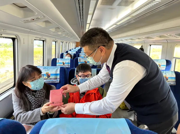 台鐵局局長杜微（右）及台東站站長鄭成忠今天分別在車上向往花東旅客致意，並致贈紀念品。台鐵局提供