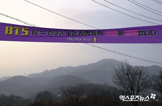 粉絲在營區掛橫幅送JIN入伍。翻攝xportsnews