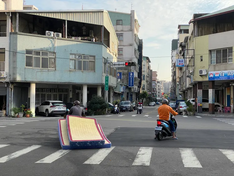 阿伯向床墊工廠要了2張床墊後綁上機車，接著準備拖去變賣。張喆喜攝