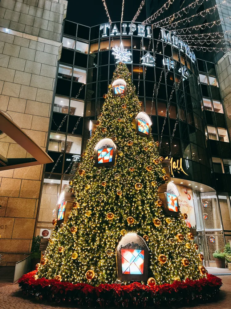 台北遠東香格里拉敦南側的遠企聖誕樹以「暖意送平安．點亮心未來」為主題設計 選用金、橘色彩球以及彩繪玻璃童話窗打造而成。台北遠東香格里拉提供