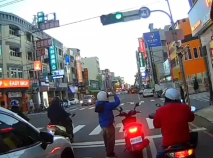 正義騎士在號誌變綠燈時，仍繼續拍攝。已阻礙交通。翻攝小饅頭社會事新聞影音