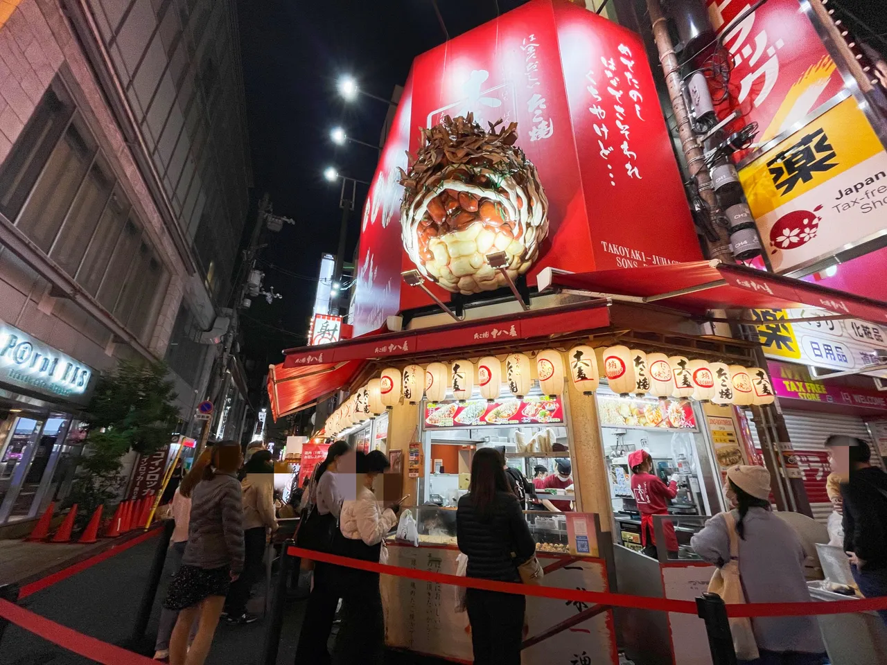 以巨型造型招牌聞名的道頓堀美食街,多數熱門商家已在店外圍起排隊紅龍。黃盈甄攝