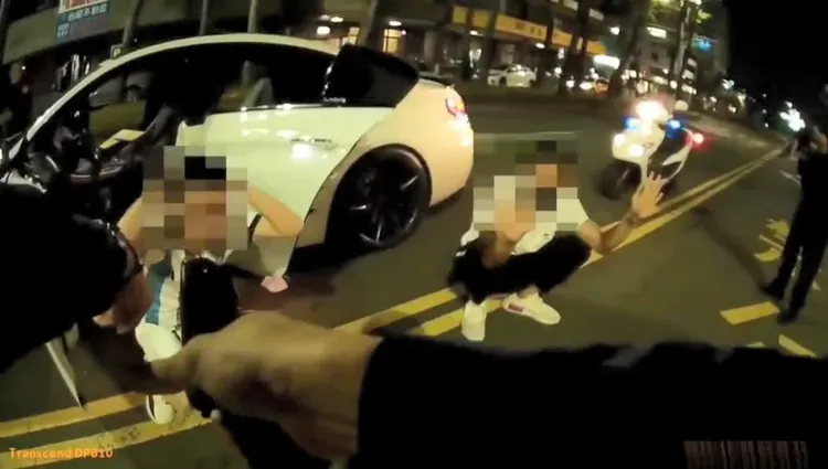 高雄行車糾紛引發7車圍堵1車，歹徒砸車又押人，警方逮捕2嫌，持槍喝令2人趴下。讀者提供