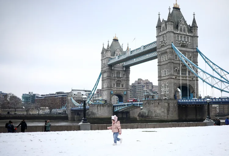 英國倫敦塔橋12日也覆上白雪，一名幼童走在雪地裡玩耍。路透社