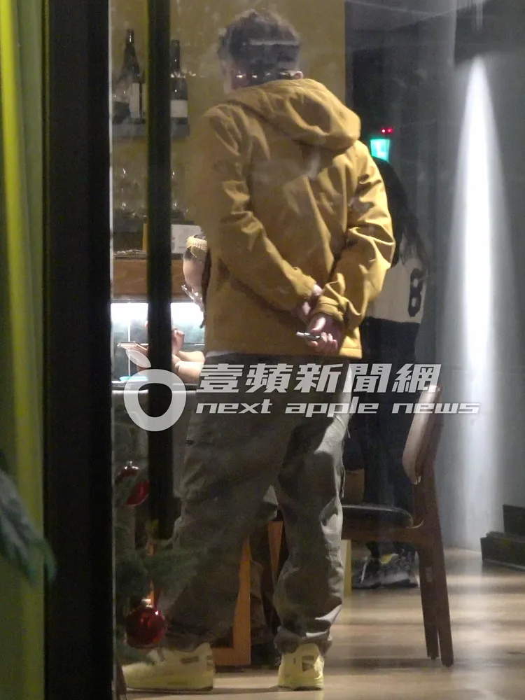 庹宗康上完洗手間，手拿加熱電子菸交叉在身後，邊聽女友人寫下白紙黑字，準備隨時哈菸。特勤中心攝