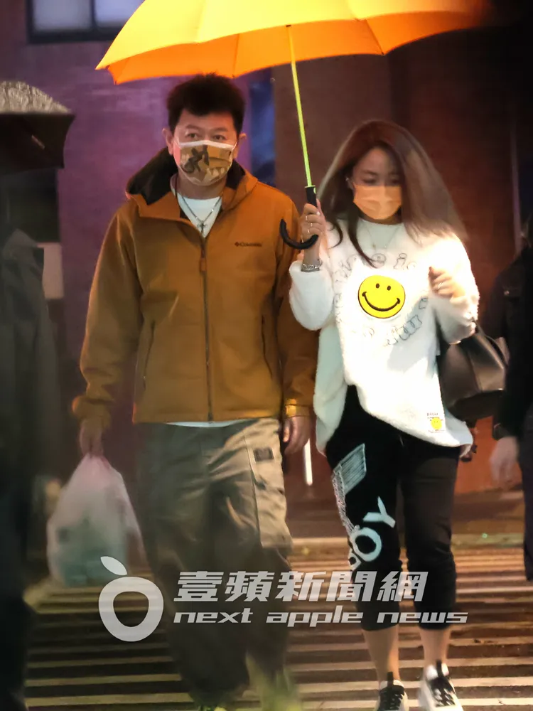 Kiki（右）幫庹宗康撐著雨傘過馬路，結婚11年感情依舊甜蜜。特勤中心攝