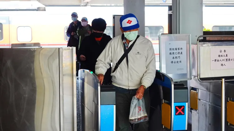 民眾進出火車站仍會配戴口罩。林泊志攝