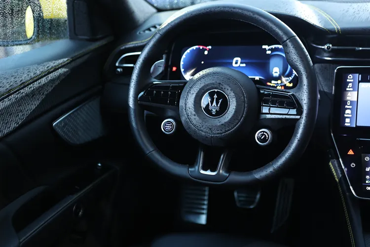 三輻跑車方向盤握感厚實，並設有行車模式選擇鍵。翁玉信攝