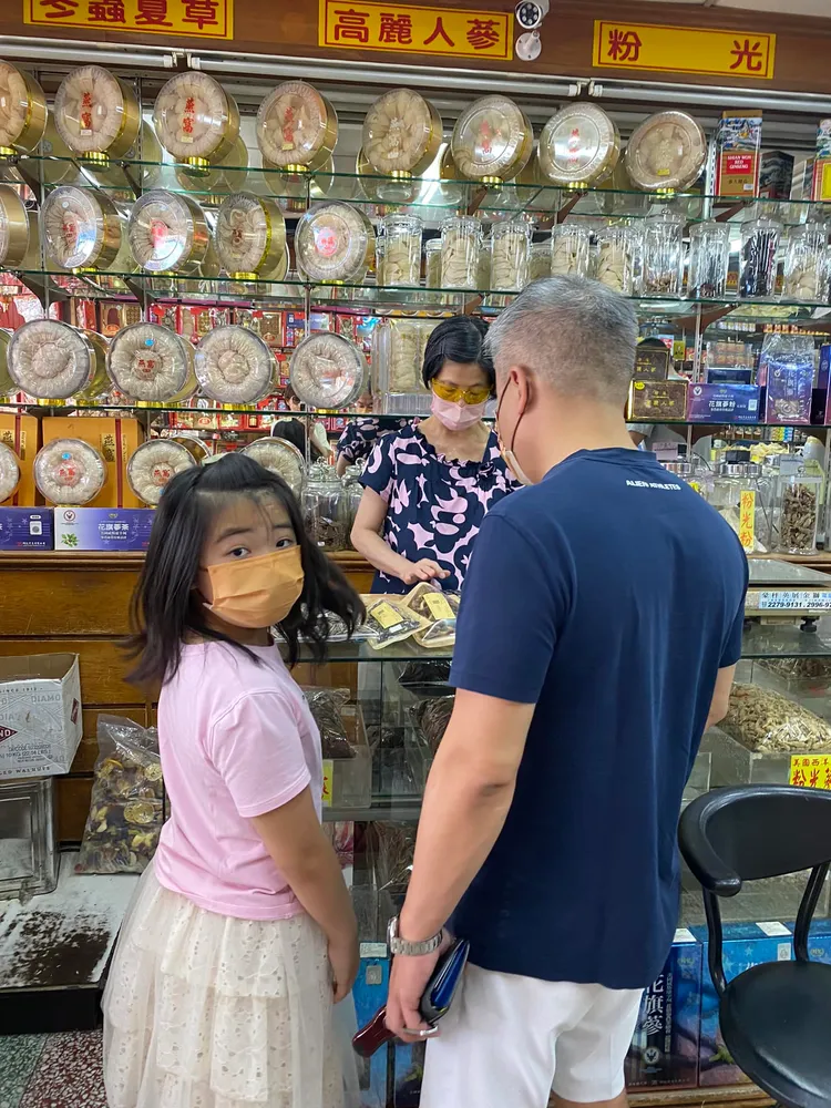 瑞秋（左）和爸爸去買中藥，轉頭瞬間媽媽又要拍，滿臉困惑。翻攝郁方臉書