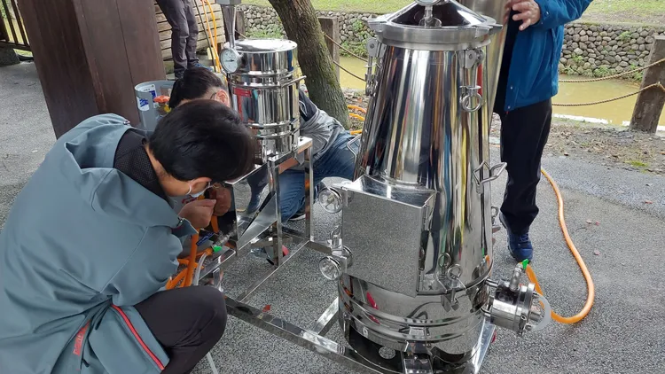 操作移動式蒸餾機。羅東林管處提供