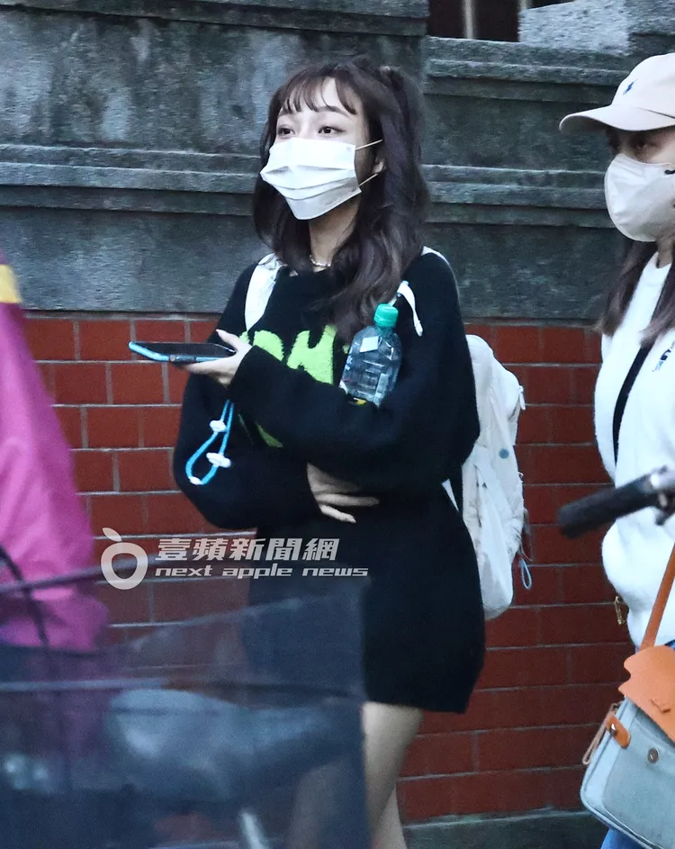 林襄綁著辮子頭抱著礦泉水，與女助理準備前往牽車的路上。特勤中心攝