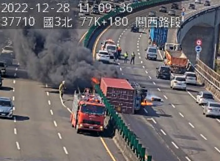 一台運載貨櫃的大貨車，因不明原因在內側車道翻覆後起火燃燒，濃煙瀰漫整個國道。翻攝自高公局1968APP