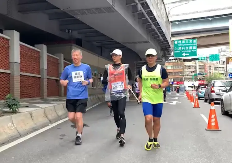陳益祥（圖左）陪伴陳奕成（圖中）完成全馬最後10公里的賽程。台大醫院提供