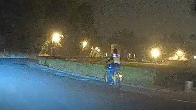 女警穿著警服、全副武裝，腰間還掛著佩槍，在街道上騎腳踏車顯得格格不入。警方提供