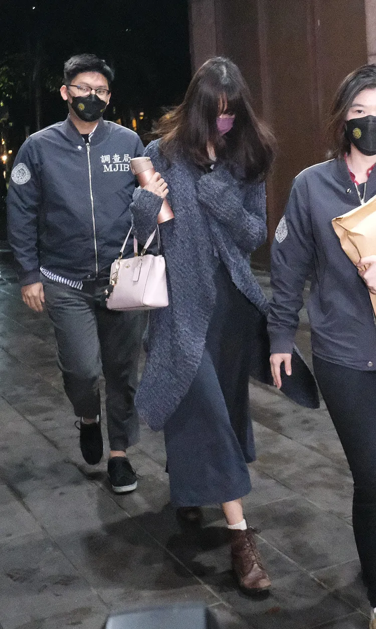台大十三妹「公衛文」晚間移送北檢複訊，她一頭長髮遮臉，手拿coach包，一路拿保溫瓶遮臉。陳志淵攝