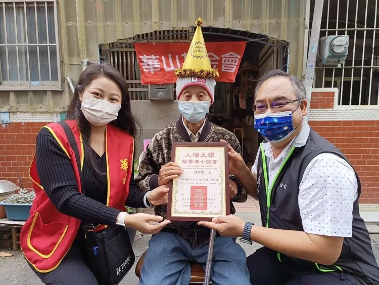 副處長邱煜斌(右)代表頒贈「人瑞榮譽博士」證書。華山提供