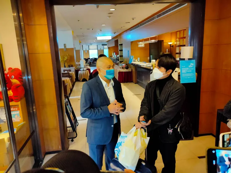 永豐棧酒店原經營團隊豐昱公司負責人何天瀚（左），向入住旅客說明情況，請他們改住其他旅館。鮮明攝