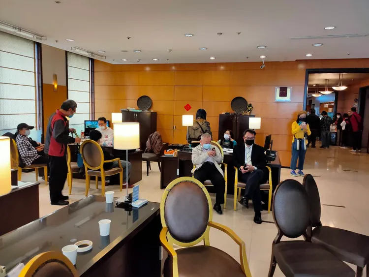 豐昱公司人員坐在酒店大廳櫃台前。鮮明攝