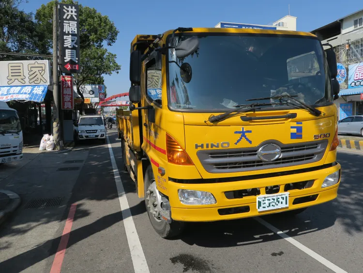 工程車為了閃避待轉機車急煞，仍後後方砂石車撞擊，又將卡在車頭的女騎士推行超過50公尺。讀者提供