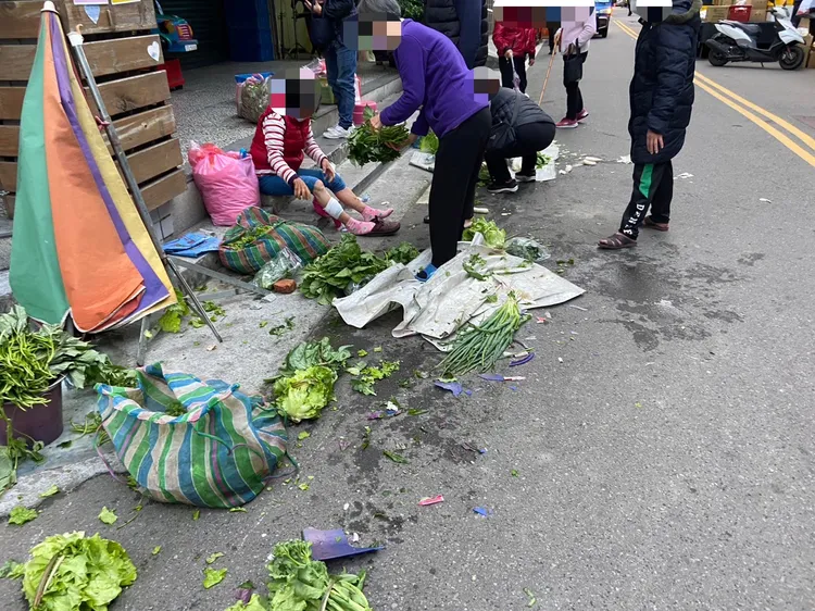 蹲坐路旁賣菜的老嫗受傷待救，辛苦栽種要販賣的青菜被輾壓毀損。民眾提供